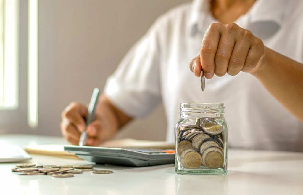 shows a man putting coins into a jar - 10 reasons insurance companies need content marketing 