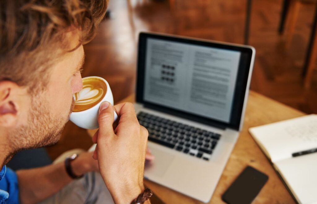 shows a man on a laptop drinking coffee - different types of blogging 