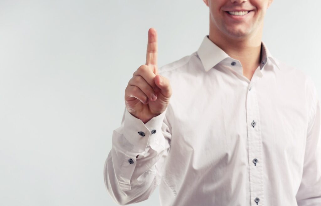 shows a man holding his second finger up - how to create a buyer persona