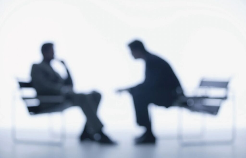 shows a blurred image of two co-workers talking - how to create a buyer persona