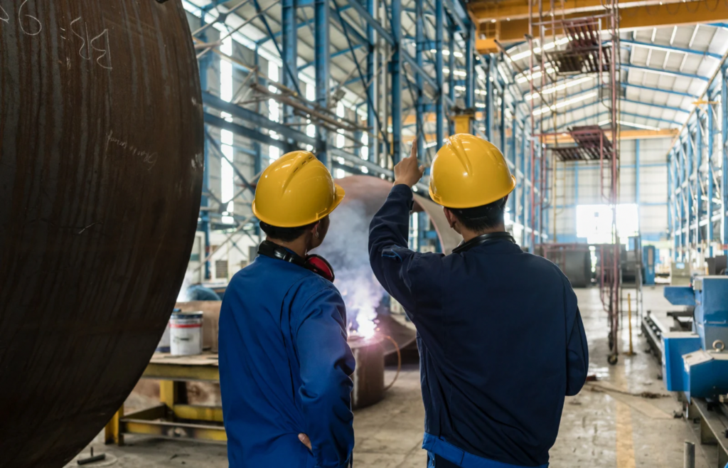 shows to workmen in yellow helmets in a factory - B2B blog post ideas