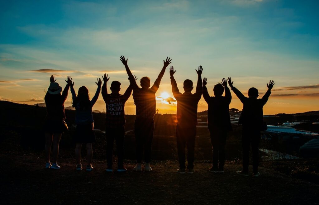 shows people with their hands in the air at sunset 