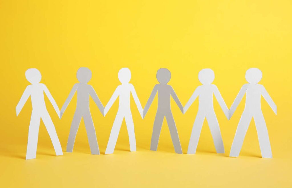 shows cut out men in white and grey on a yellow background