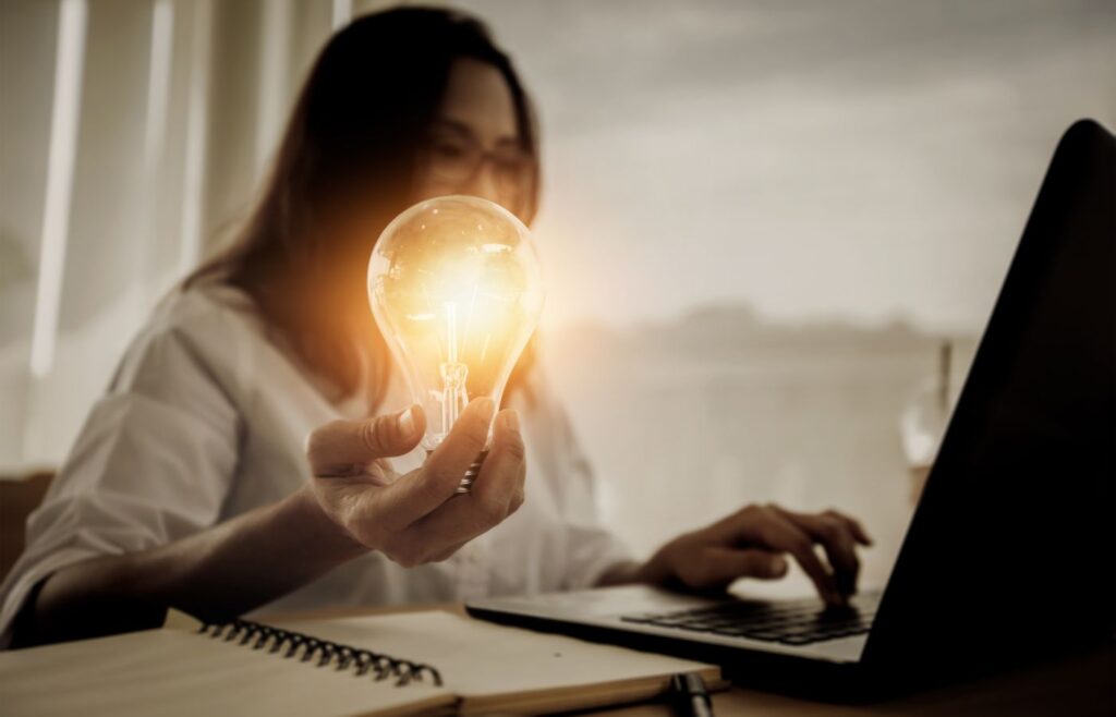 shows a woman holding a light bulb in her hand 