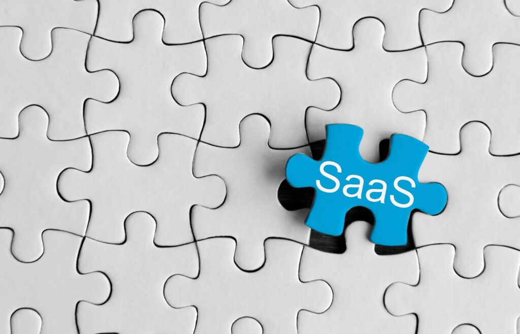 shows a jigsaw puzzle with the word ,'SaaS' in blue - SaaS copywriting guide 